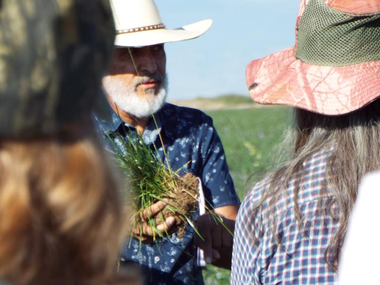 Man holding a bundle of grass